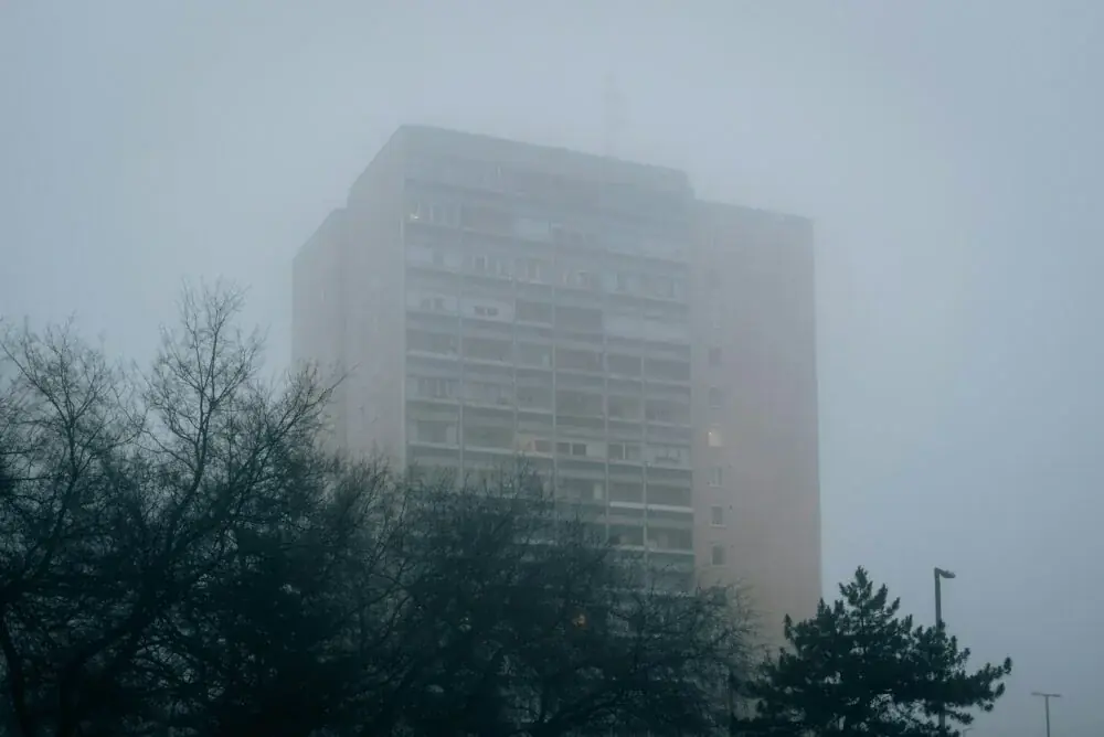 a very tall building in the middle of a foggy day