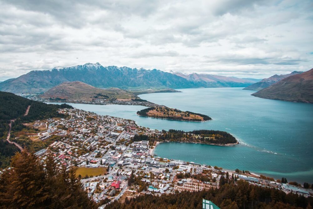 aerial photography of white houses near body of water under Queenstown white clouds at daytime