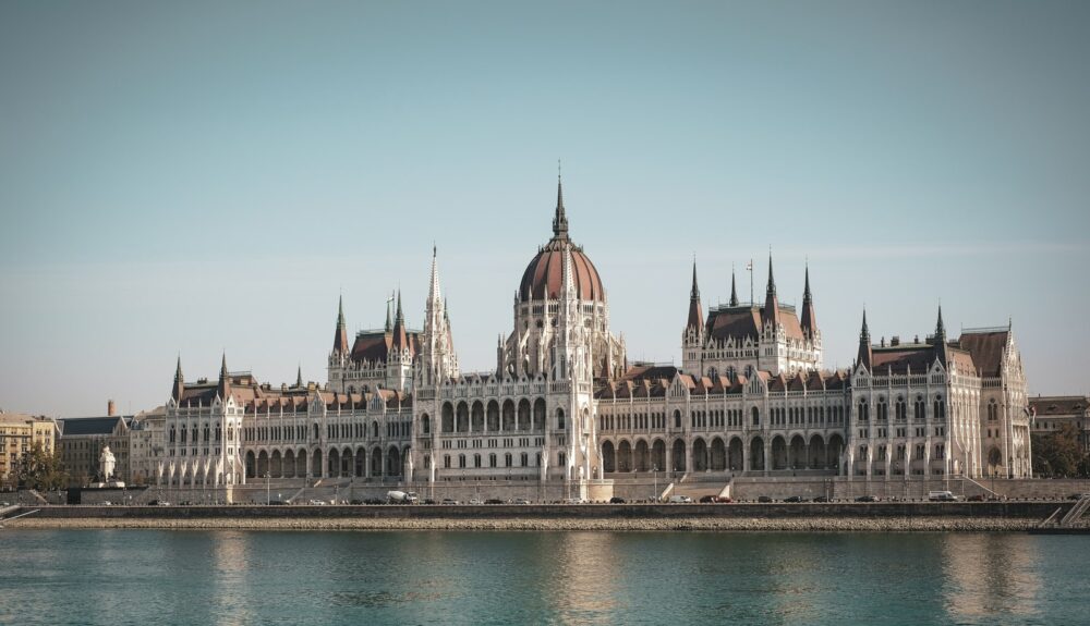 white and brown concrete building near body of water during daytime